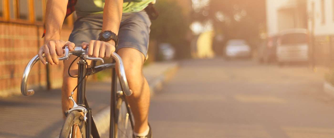 Rapaz andando de bicicleta em dia ensolarado